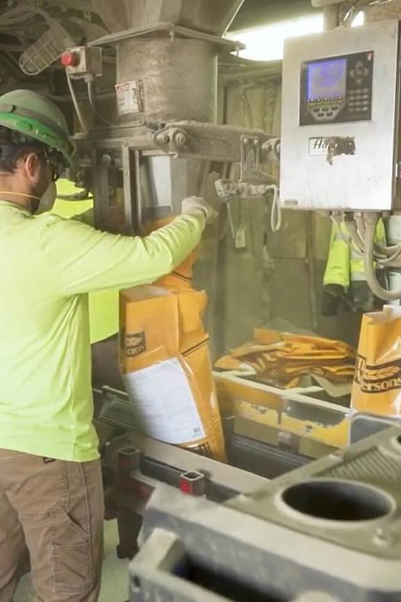 An individual filling product bags at an operations location