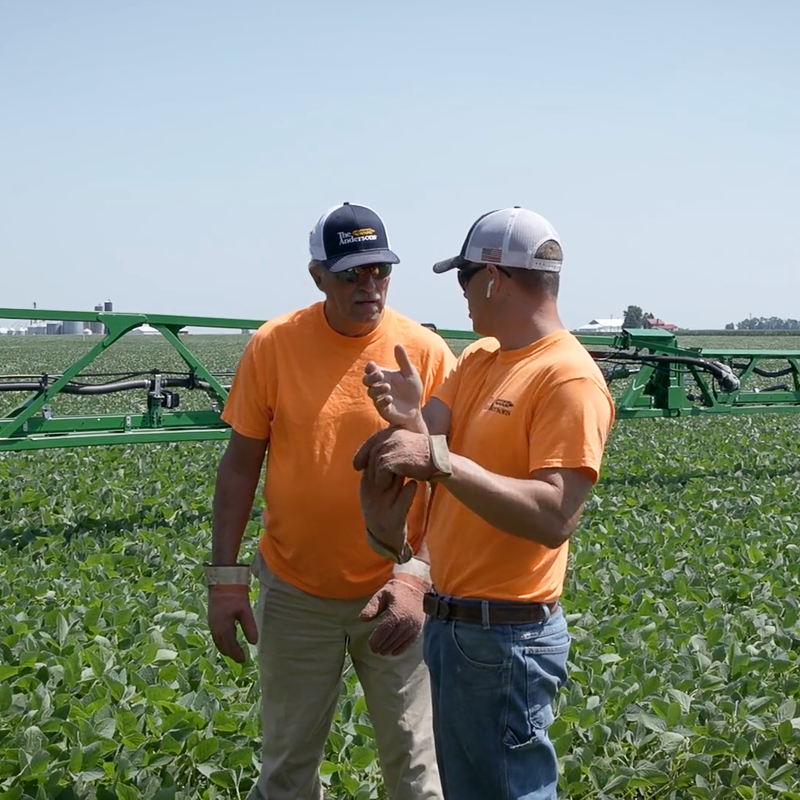 Two people talking in soybean field